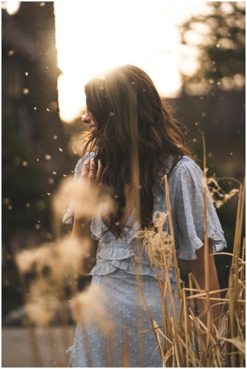 A woman in a blue dress enjoying the golden hour i