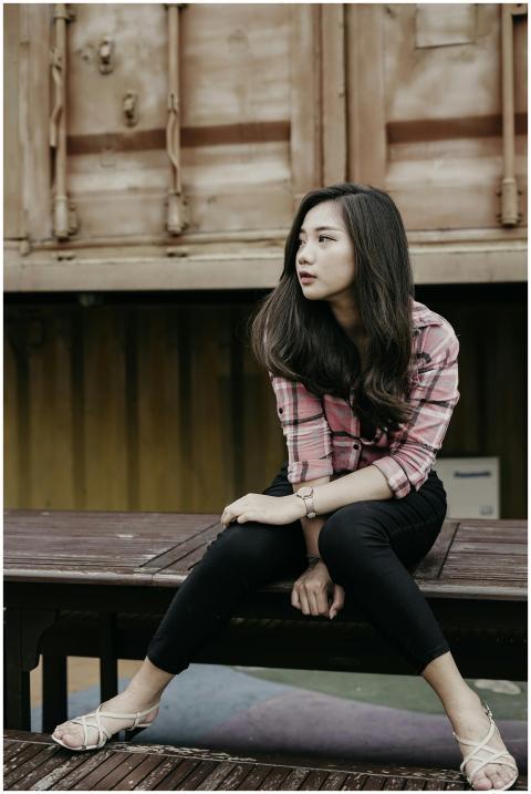 Stylish young woman in plaid shirt posing casually