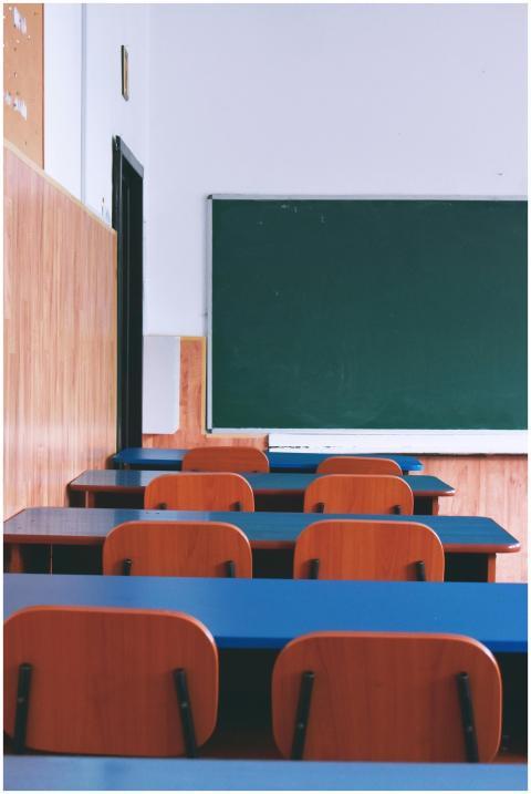 A serene view of an empty classroom with wooden de