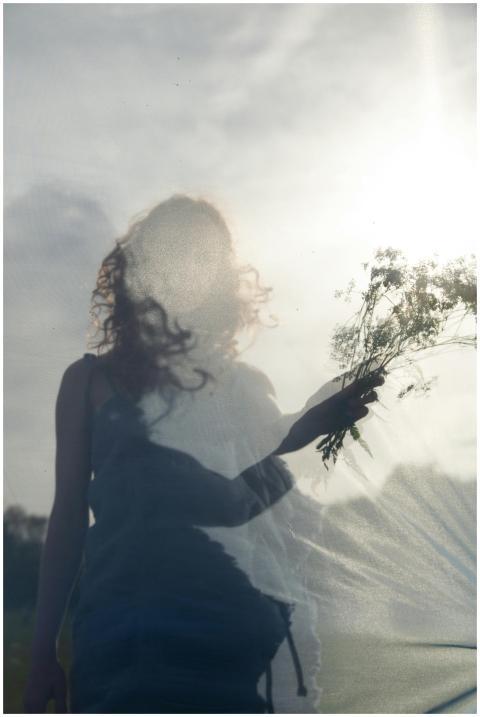 Artistic silhouette of a woman with flowers agains