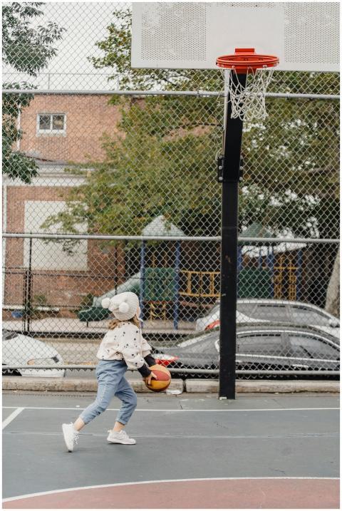 A child enjoys a basketball game in an outdoor cou