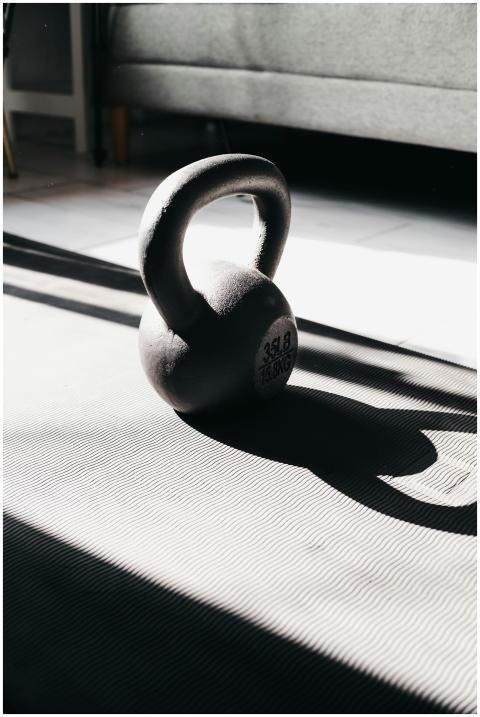 Kettlebell in bright sunlight casting shadow on gy