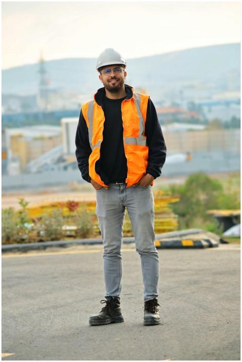 A construction worker stands confidently outdoors