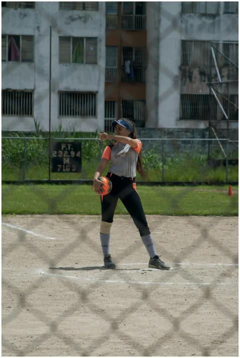A woman athlete playing softball on an outdoor spo