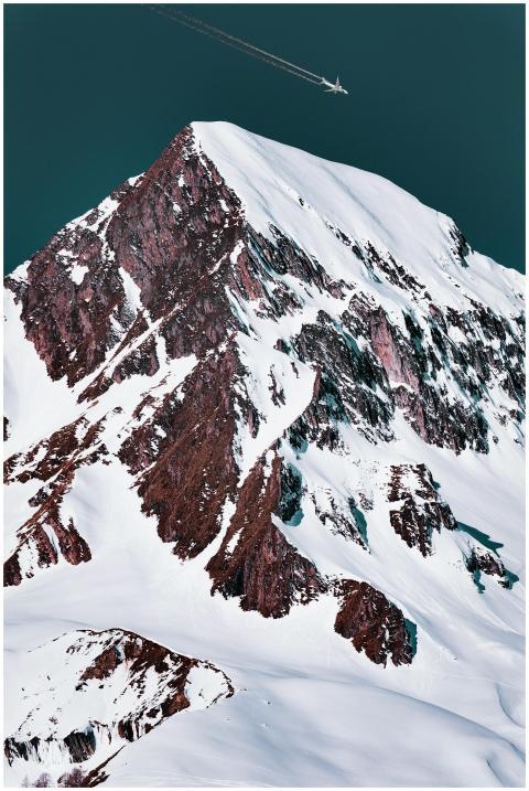 Epic aerial shot of a snowy mountain summit with a