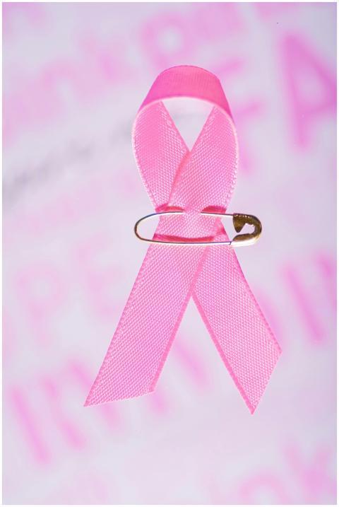 Close-up of pink ribbon with safety pin for breast