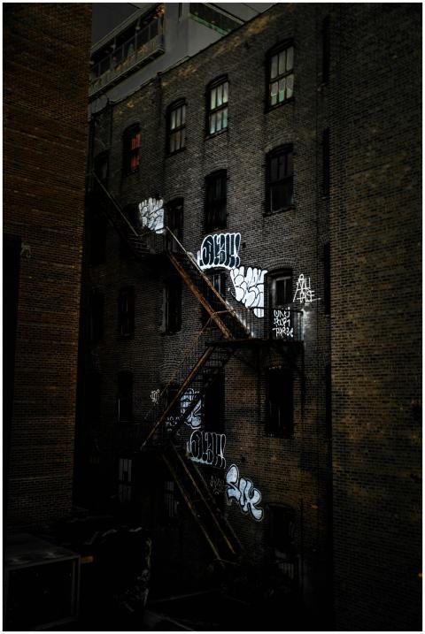 Black and white graffiti on a brick building's ext