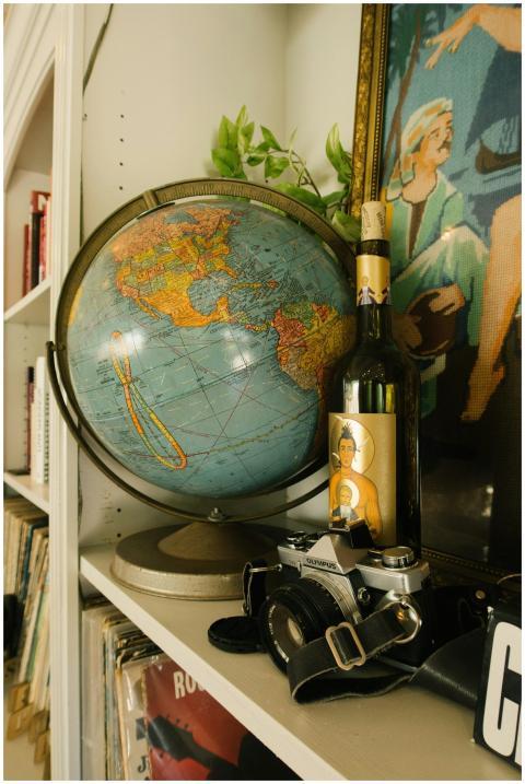 Vintage globe, wine bottle, and camera on a shelf