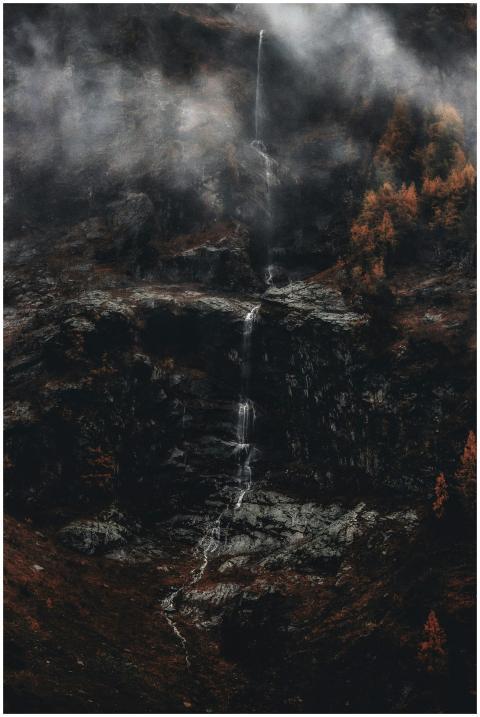 A serene waterfall cascades down rocky cliffs, env