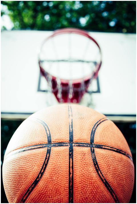 Vivid image of a basketball aiming for a hoop outd