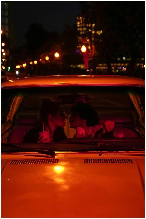 A couple sharing a romantic moment inside a car at
