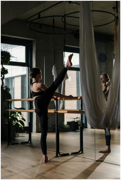 A woman practices barre exercises in a yoga studio
