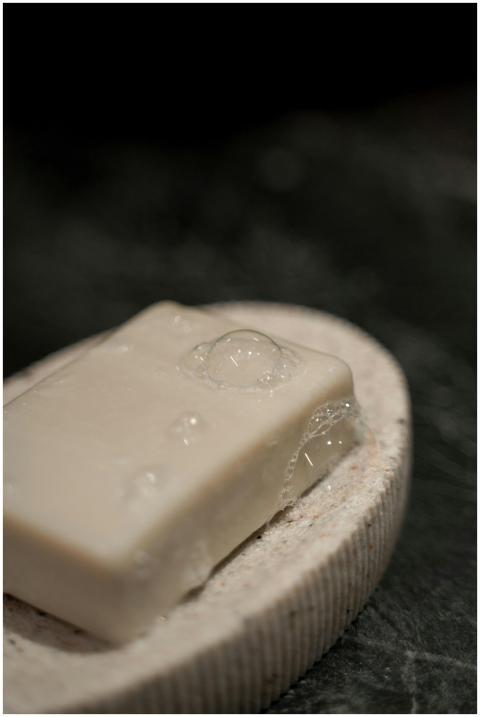 Close-up of a soap bar with bubbles on a stone hol