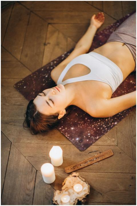 Woman practicing relaxation yoga with candles set