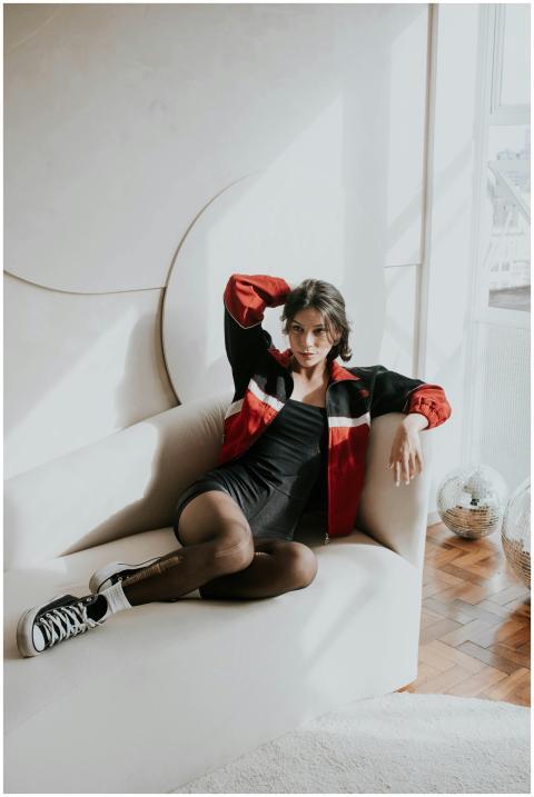 A stylish woman in a red jacket and black dress lo