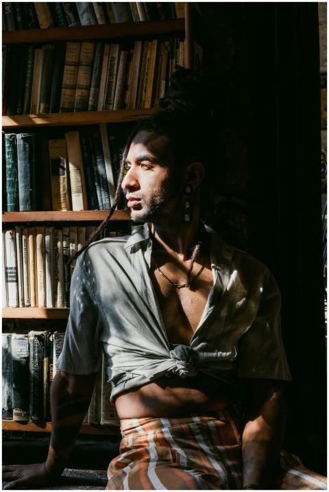 Fashionable man with dreadlocks posing indoors by