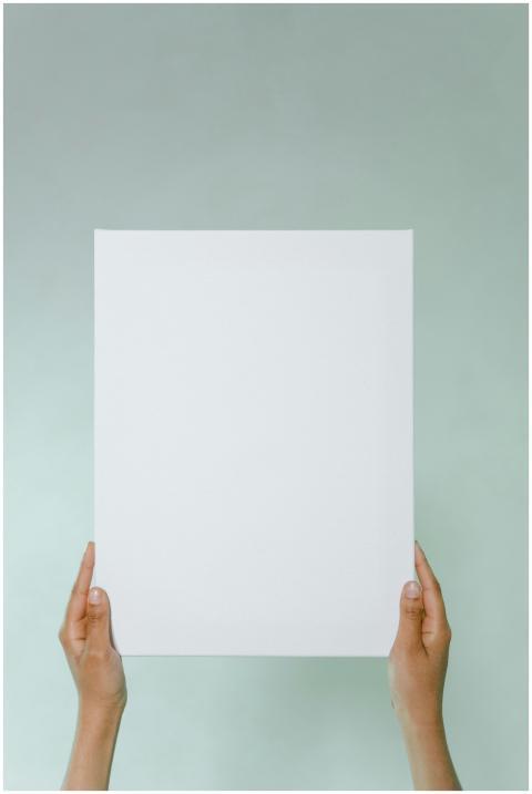 Close-up of hands holding a blank white paper agai