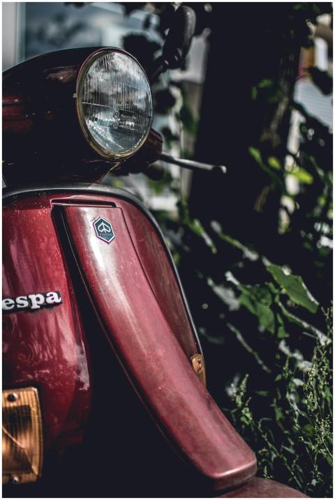 Moody and vintage close-up of a classic red Vespa