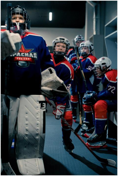 Youth hockey team getting ready with safety gear i