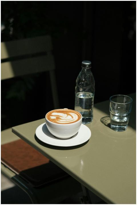 A warm café scene featuring a latte with art, a gl