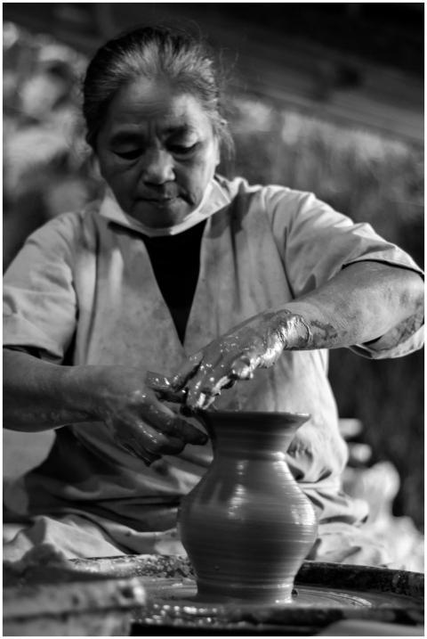 A senior woman skillfully creating pottery by hand