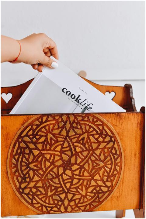 A hand placing a magazine titled 'cook life' into