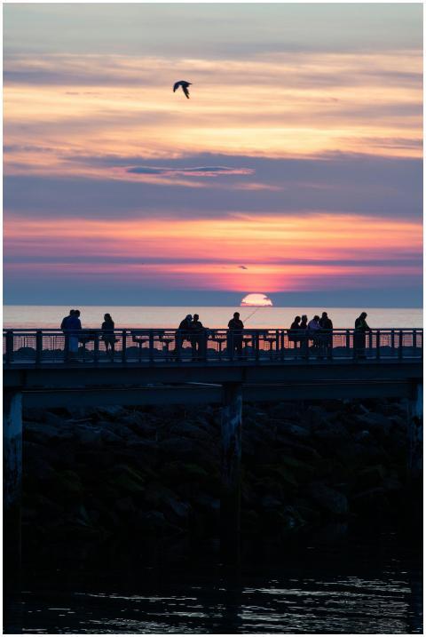 Silhouetted people enjoy a vibrant sunset over Mat
