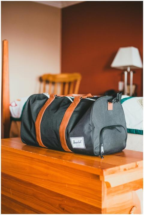 Elegant black gym bag with brown straps on a woode