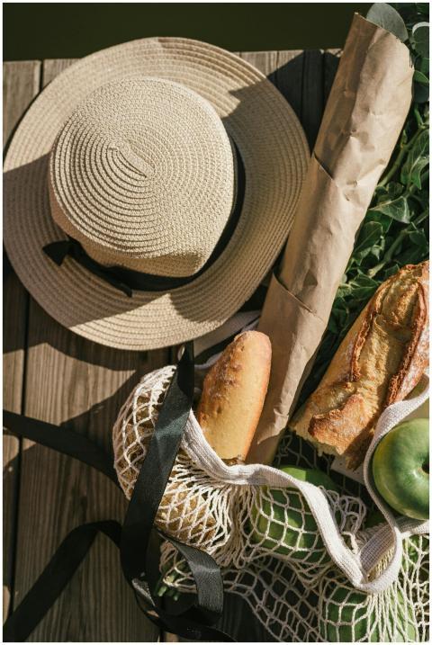 Top view of summer picnic items including a hat, b