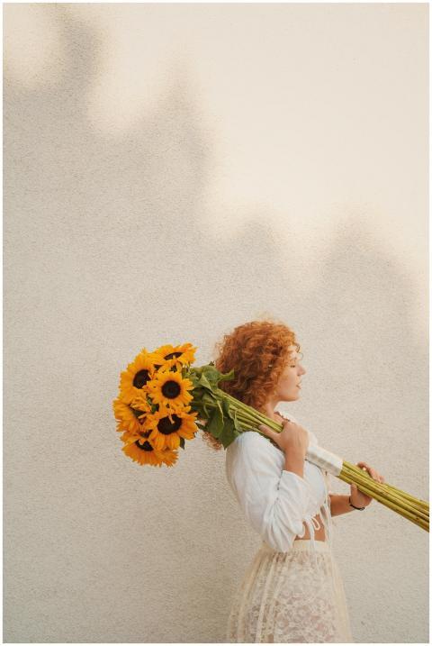Side view of a woman with curly hair carrying a bo