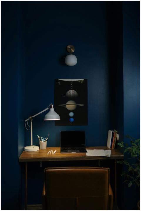 A modern workspace setup with a desk lamp, laptop,