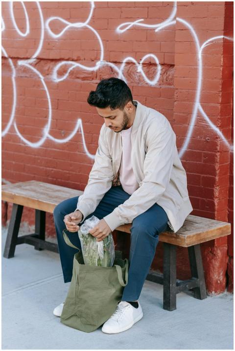 Stylish young Indian male with modern haircut sitt