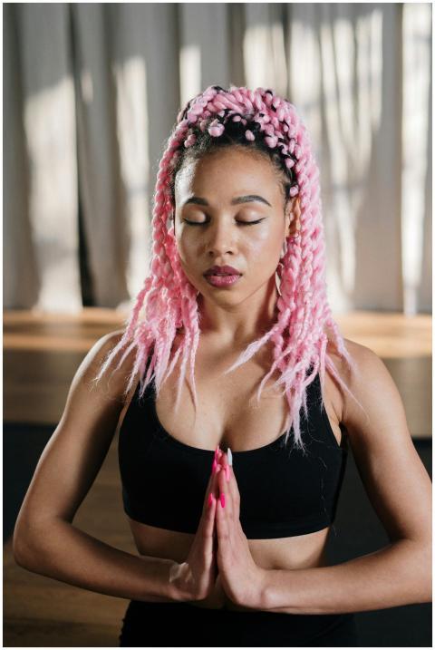 A woman practicing yoga indoors with vibrant pink
