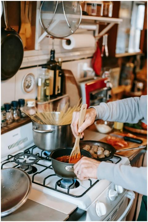 A person stirs homemade tomato sauce while cooking