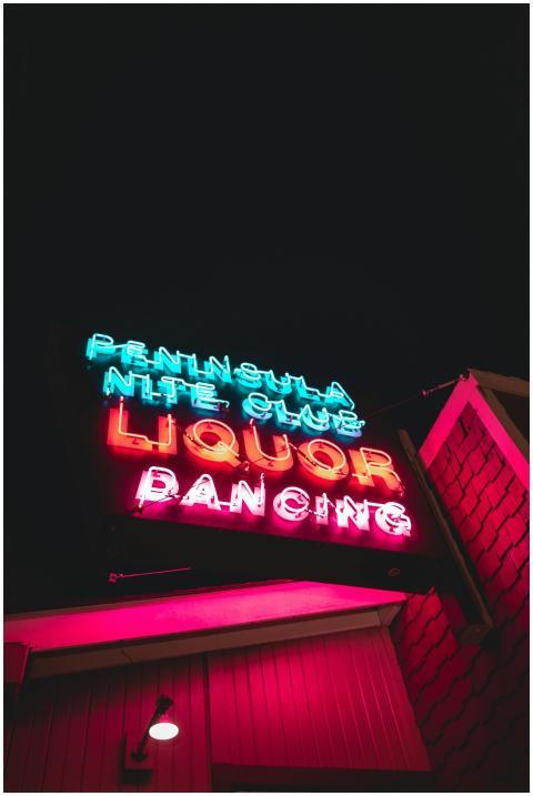 Vibrant neon signage displaying 'Peninsula Nite Cl