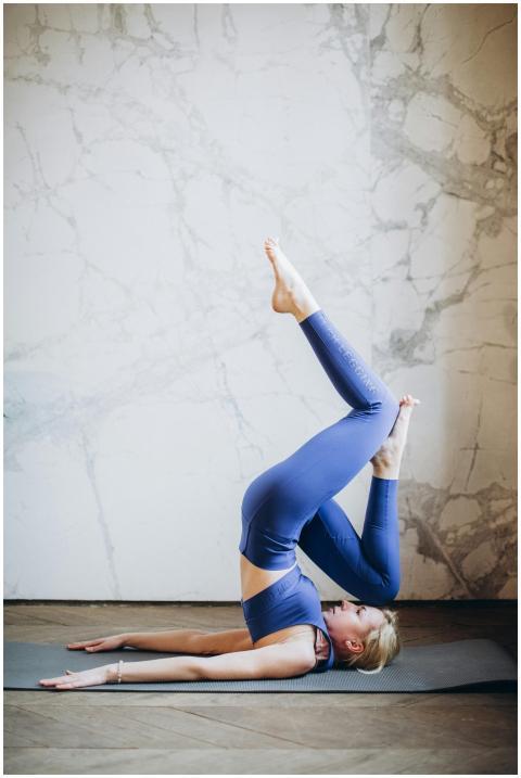 Woman performs advanced yoga pose indoors, showcas