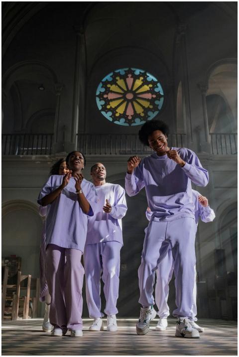 Group of singers in a cathedral with stained glass