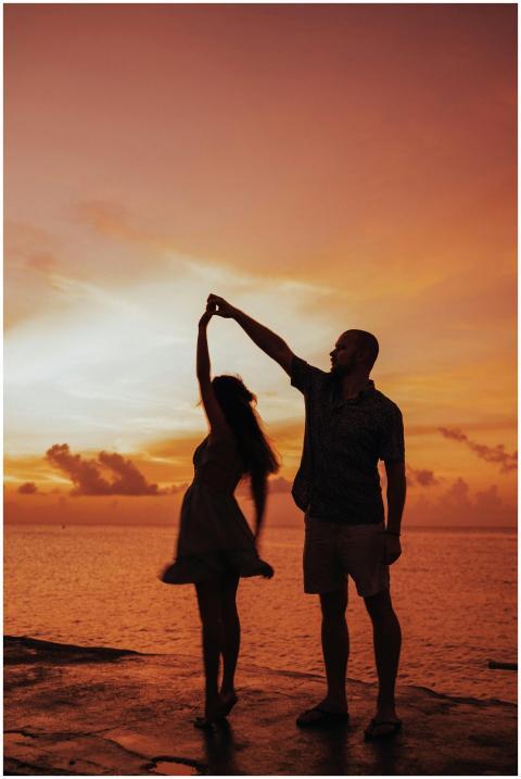 A couple dances at sunset by the sea, capturing a
