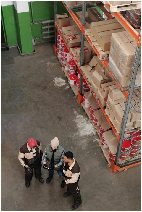 Group of warehouse workers discussing logistics an