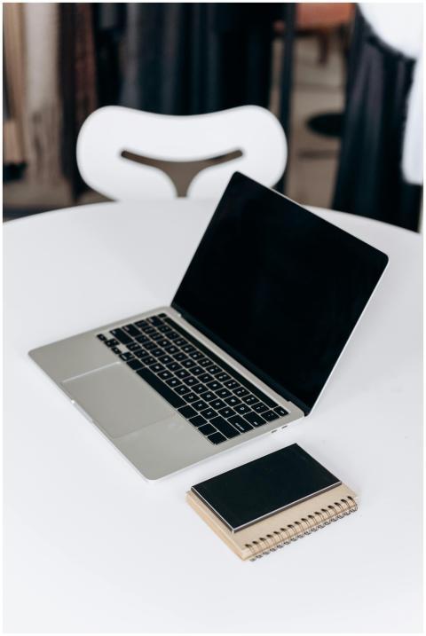 Sleek laptop with a closed notebook on a pristine