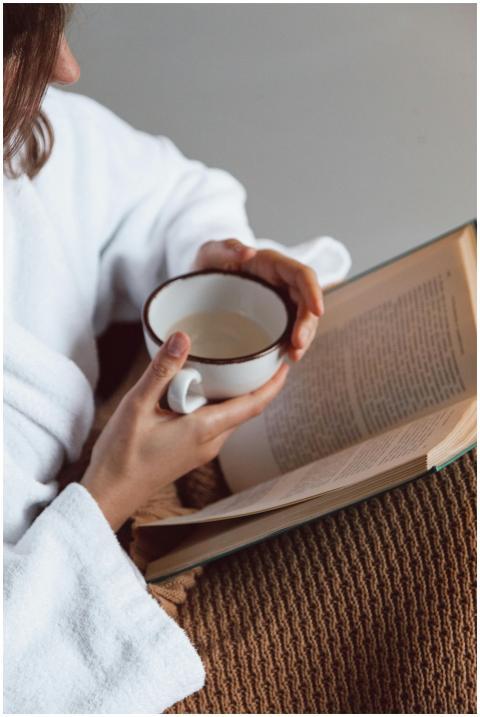A person enjoying a cozy moment with a book and a