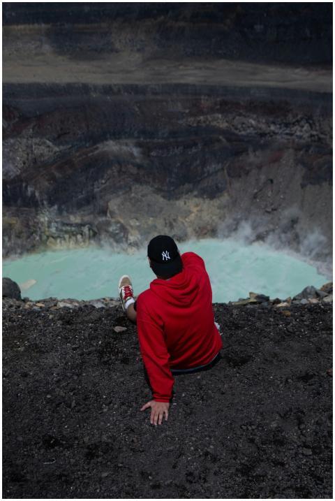 An adventurous person overlooks Kawah Ijen's sulfu