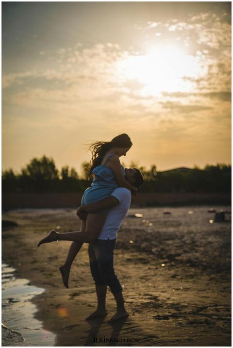 A loving couple embraces during a romantic sunset