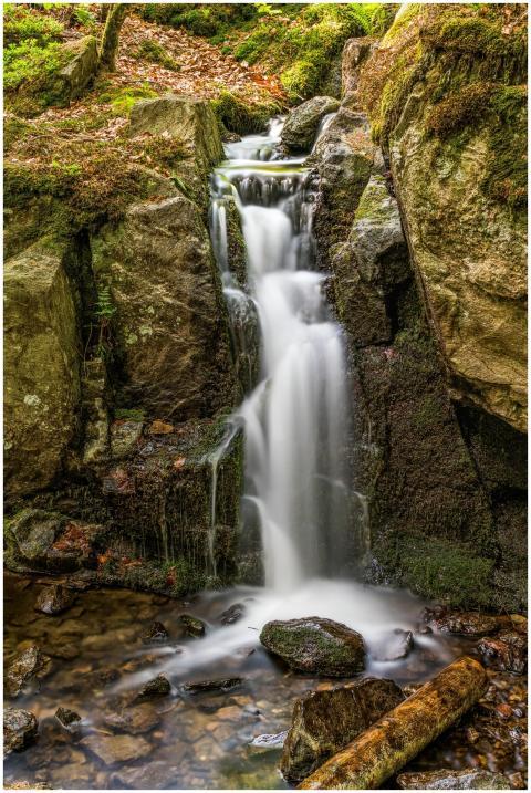 Peaceful waterfall cascading over mossy rocks in a