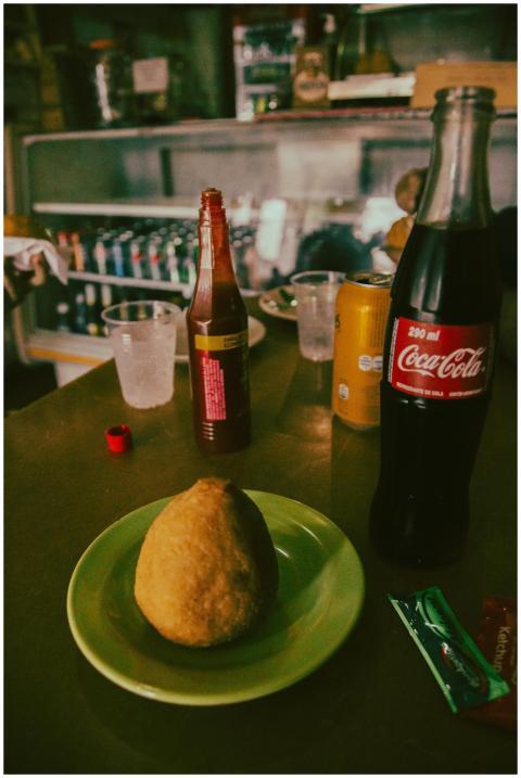 Brazilian snack coxinha with sauce and a bottle of