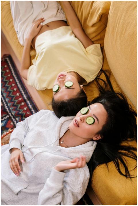 Two women enjoying a relaxing spa day with cucumbe
