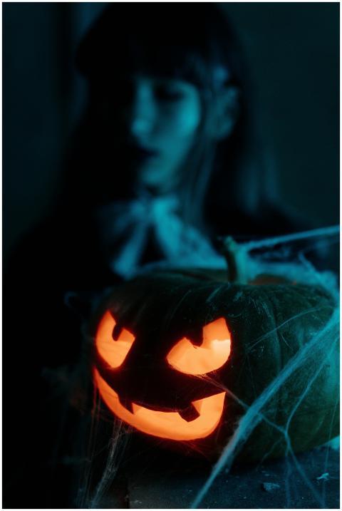 Creepy illuminated jack-o'-lantern with cobwebs in
