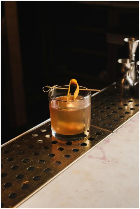 A classic old fashioned cocktail with orange garni