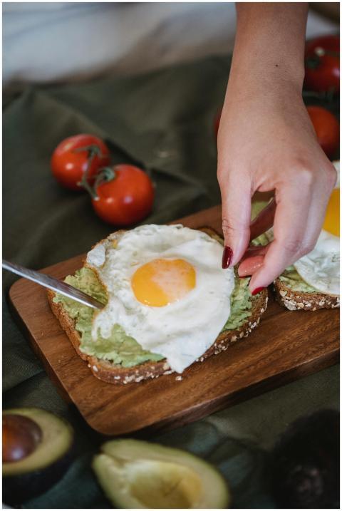 Close-up of avocado toast with fried eggs and ripe