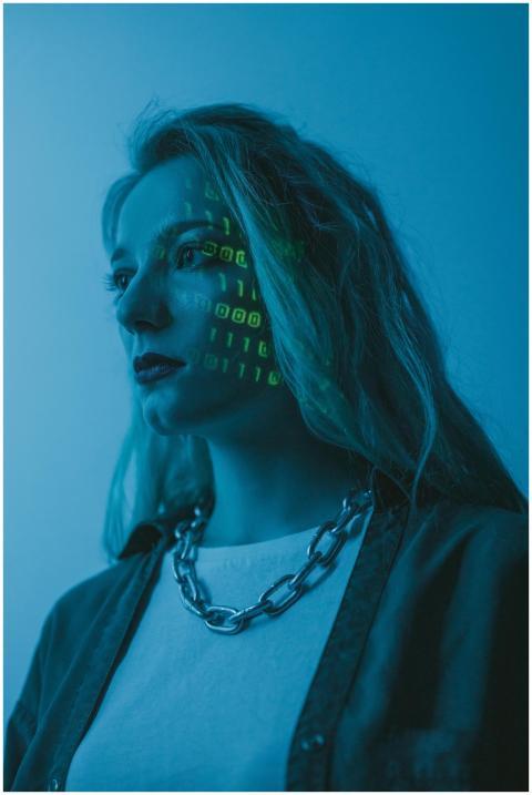 Woman with illuminated binary code on her face, ar